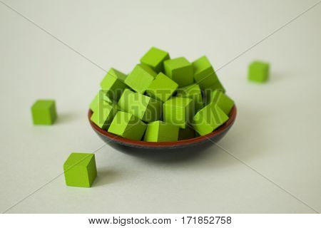 Green cubes piled up in a dish.