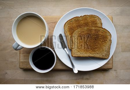 A cup of coffee, some jam and toast.