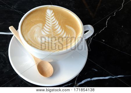 Coffee Cup With Latte Art Rosetta Pattern On The Black Marble Table
