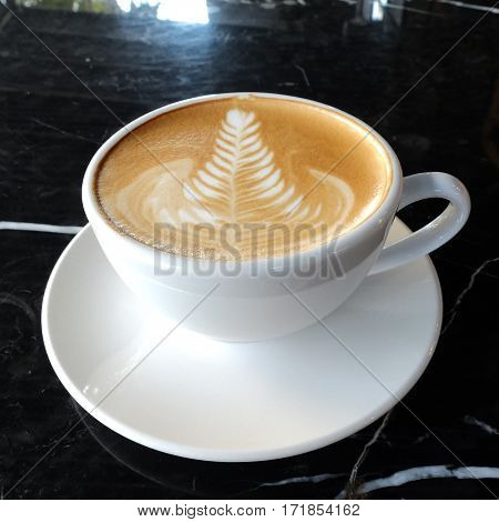 Coffee Cup With Latte Art Rosetta Pattern On The Black Marble Table