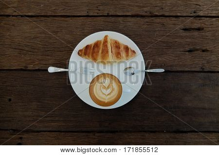Coffee Cup With Latte Art And Croissant On The Wood Table