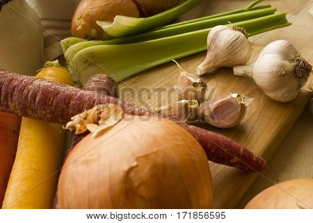 An assortment of fresh vegetables on a wooden block.