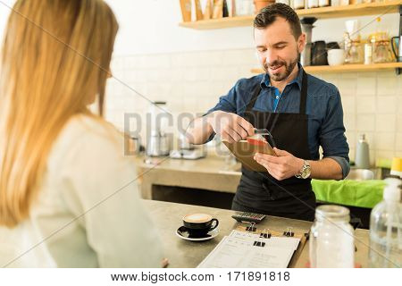 Barista Swiping Credit Card In A Coffee Shop