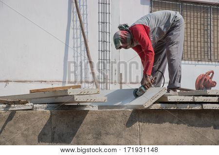 Builder Worker With Grinder Machine Cutting Concreate Floor At Construction Site