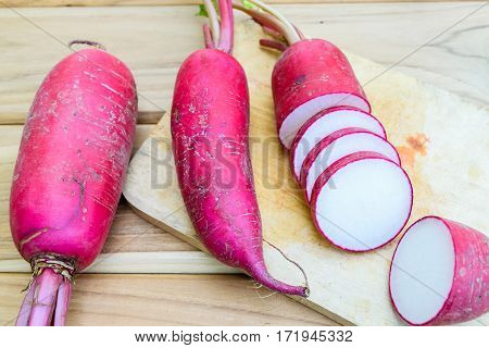 Red radish on wooden bord on wooden table