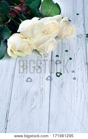 Beautiful white roses on white wooden background. Copy space