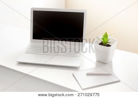 Completely White Modern Workspace With Laptop, Notepad, Plant And Pen. Minimal Pure Consept