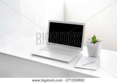 Completely White Modern Workspace With Laptop, Notepad, Plant And Pen. Minimal Pure Consept