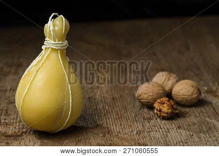 Typical Italian Cheese Caciocavallo With Walnuts On A Wooden Surface. Selective Focus.