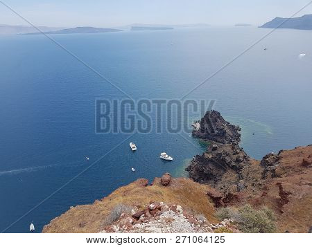 Boats In The Sea In Front Of Santorini, Greece.