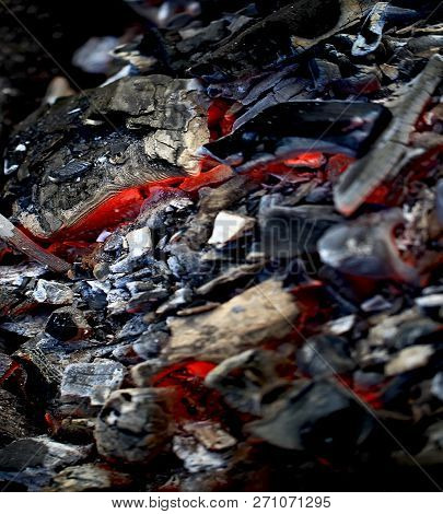 Burning Coals In The Barbecue On A Blurred Background, The Texture Of The Flame