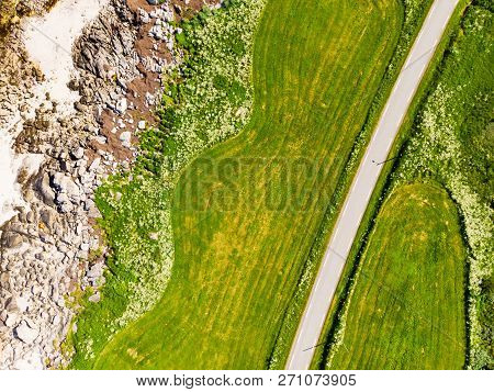 Aerial Top Down View Of Country Road Through Green Land Field Along Sand Beach Seashore, Gimsoya Isl