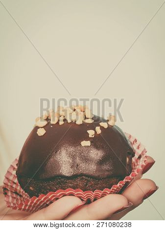 Diet, Sweets, Food Concept. Woman Hand Holding Delicious Chocolate Cupcake With Peanut Frosting Abou