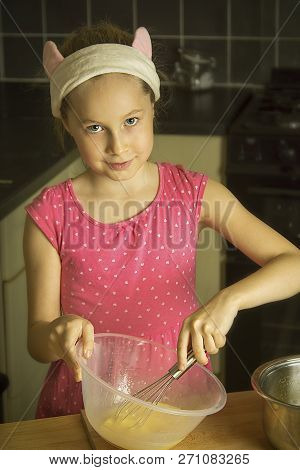 Cute Little Girl Cooking Muffins At Kitcen. Close Up Portret.
