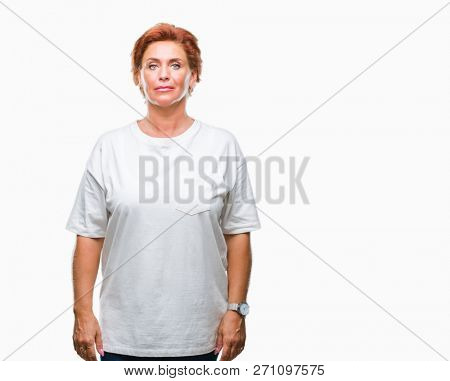Atrractive senior caucasian redhead woman over isolated background with serious expression on face. Simple and natural looking at the camera.