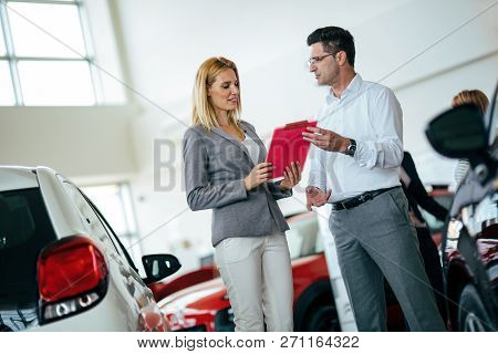 Handsome Salesman At Car Dealership Selling Vehichles