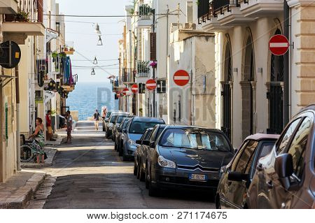 Polignano A Mare, Italy - July 6 2018: People Walk Along Parked Cars On Street With Many No Entry Tr