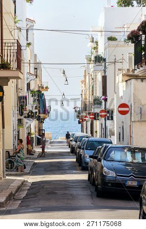Polignano A Mare, Italy - July 6 2018: People Walk Along Parked Cars On Street With Many No Entry Tr