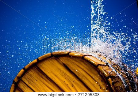 Water Jet On Barrel On Blue Background