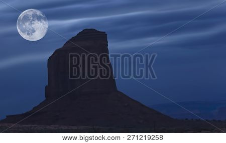 View Of A Risng Moon Over Monument Valley