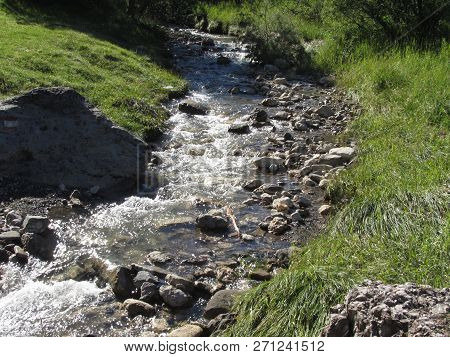 Water Flowing And Splashing Over Rocks In A Mountain River Stream