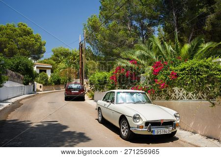 Santa Ponsa, Mallorca, Spain - July 24, 2013:  Retro Car Mg Bgt Is Parked Near A Wall With Flowers A