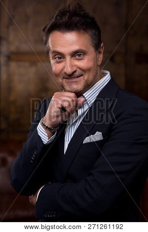 Elegant Stylish European Man Posing With His Fingers Touching The Chin And Smiling