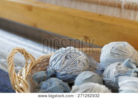 Closeup Of Basket Full Of A Blue, White And Brown Ball Of Matte Crumble. A Loom In The Background