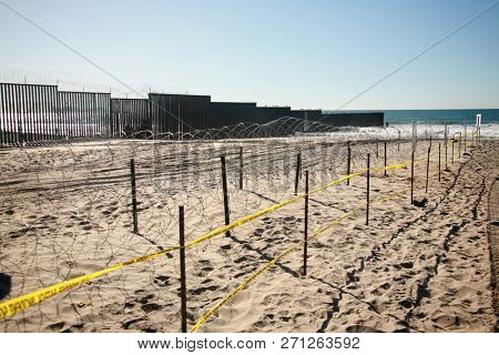 San Ysidro, California - 11/26/2018: Border fence between the USA and Mexico including New Construction adding an additional layer of fencing and razor wire or barbed wire to secure the border.