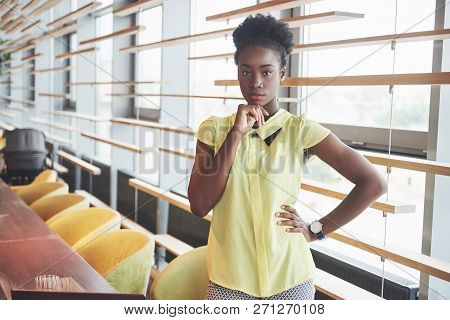Young African American Girl With Dark Curly Hair Pensive In A Cafe. Beautiful Cozy Place.