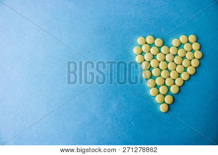 Small Medical Pharmaceptic Round Yellow Pills, Vitamins, Drugs, Antibiotics In The Form Of A Heart O