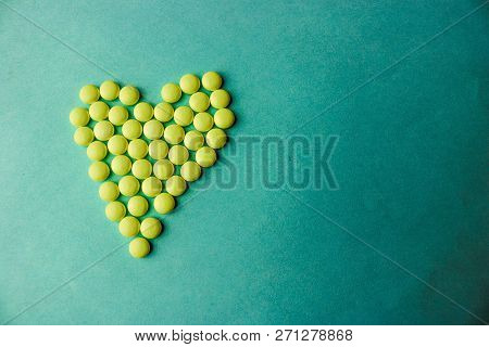 Small Medical Pharmaceptic Round Yellow Pills, Vitamins, Drugs, Antibiotics In The Form Of A Heart O