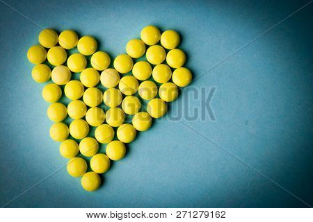 Small Medical Pharmaceptic Round Yellow Pills, Vitamins, Drugs, Antibiotics In The Form Of A Heart O