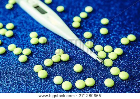 Small Medical Pharmacetic Round Tablets, Vitamins, Drugs And Electronic Digital Thermometer On A Blu