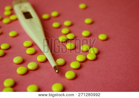 Small Medical Pharmacetic Round Pills, Vitamins, Drugs And Electronic Digital Thermometer On A Pink 