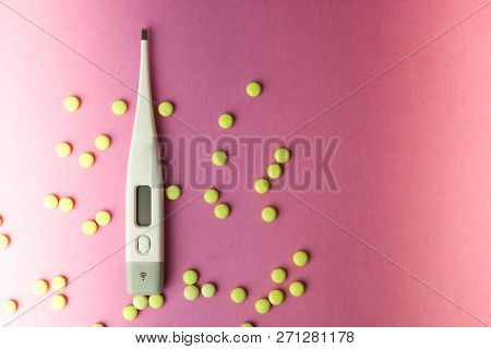 Small Medical Pharmacetic Round Pills, Vitamins, Drugs And Electronic Digital Thermometer On A Pink 