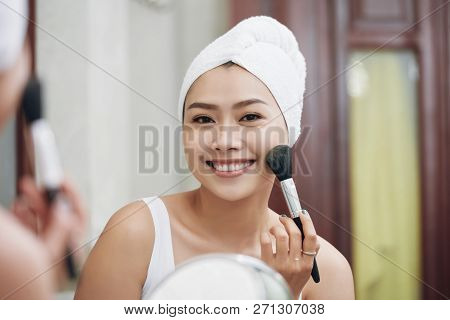 Pretty Happy Young Vietnamese Woman Applying Make-up In Morning