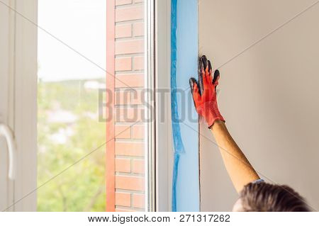 Man In A Blue Shirt Does Window Installation