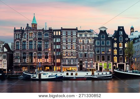 Night Amsterdam City View Of Netherlands Traditional Houses With Amstel River In Amsterdam, Netherla