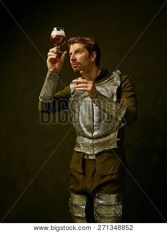 Medieval Knight With Beer On Dark Studio Background. Portrait In Low Key Of Brutal Man In Tradishion
