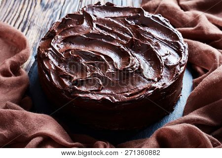 Close-up Of Homemade Chocolate Fudge Cake Topped With Chocolate Ganache On A Black Stone Plate With 