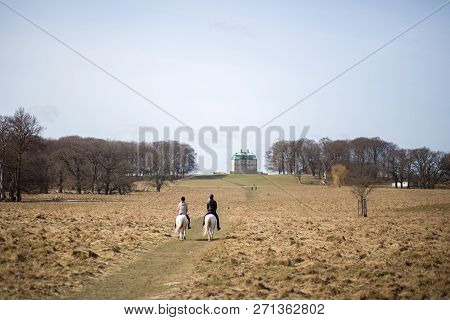 Klampenborg, Denmark - March 25, 2017:  Two Horse Riders In Front Of The Small Castle Inside The Dee