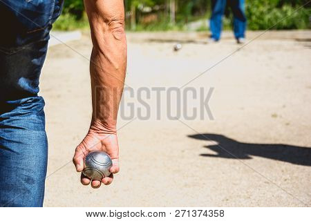Senior People Prepared To Throw The Boules Ball In A Park In Outdoor Play