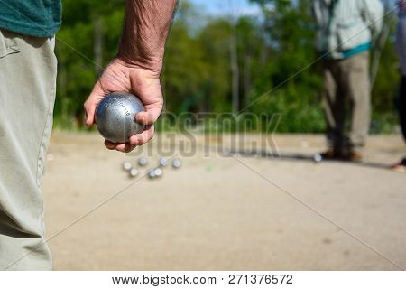 Senior People Prepared To Throw The Boules Ball In A Park In Outdoor Play