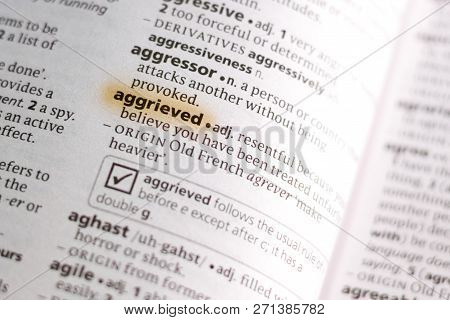 The Word Or Phrase Aggrieved In A Dictionary Highlighted With Marker.