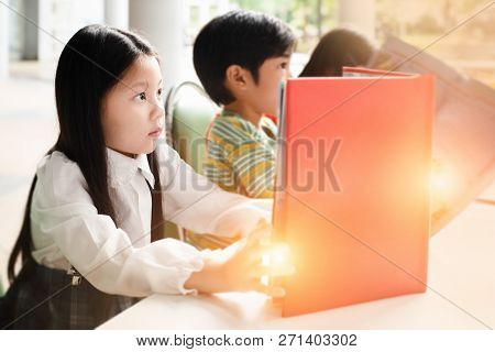 In Selectivefocus Of Little Girl Is Reading Book,warm Light Tone,blurry Light Design Background
