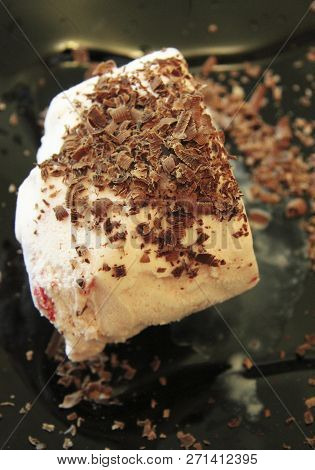 Chocolate Ice Cream And Hardered Chocolate Over Ready For Eat On The Black Plate