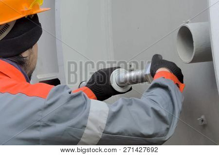 Moscow, Russia - May 20, 2017: The Worker Twists The Nuts. Worker Of The Plant. Worker In A Helmet.