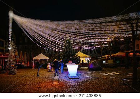 Strasbourg, France - Nov 29, 2017: People Gathering Under Large Multicolored Garland In Place Du Mar