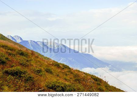 Landscape - View From The Mountain Top On A Sunny Day To The Valley Hidden By Low Clouds